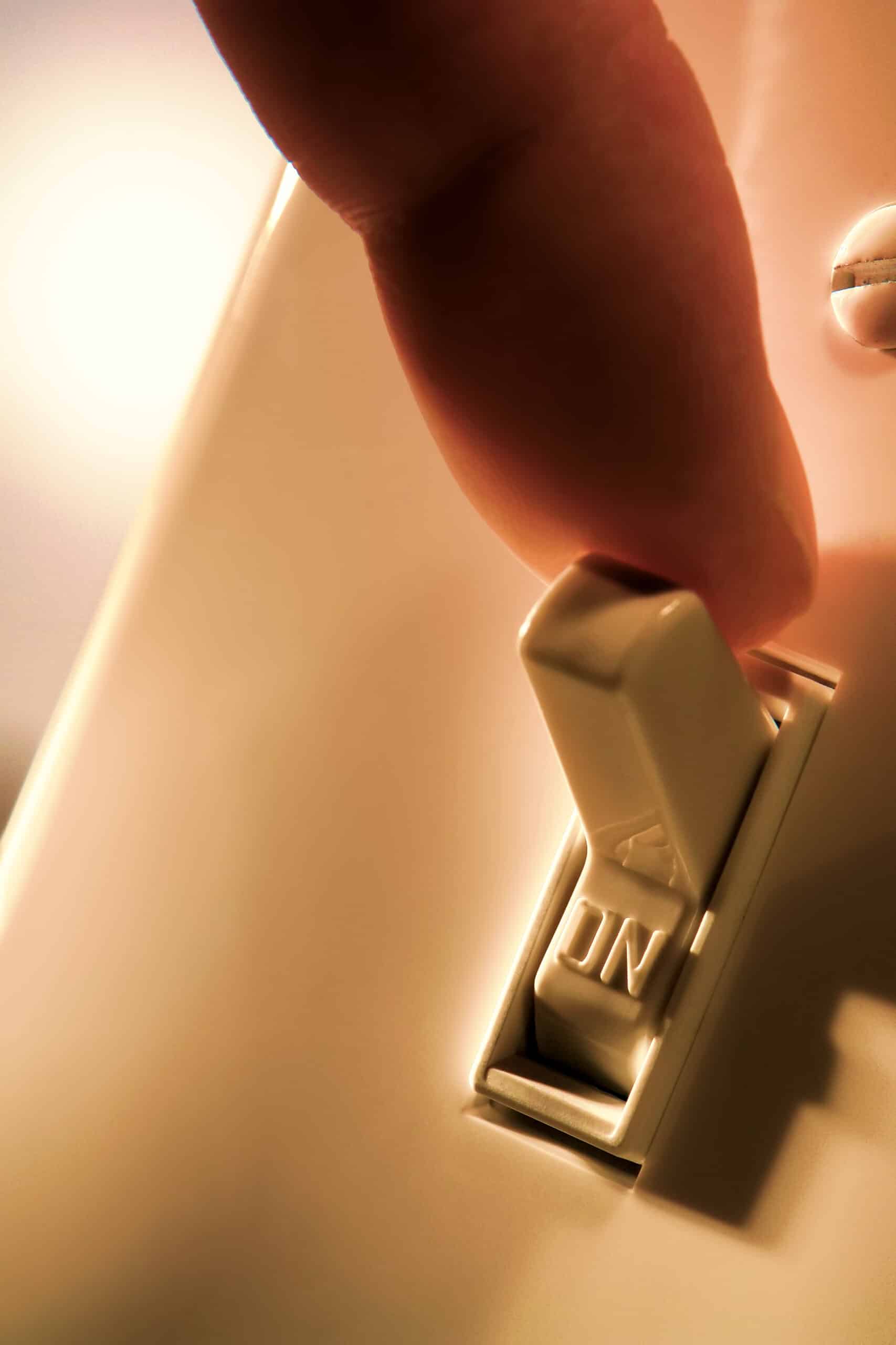 Close up image of a finger turning off a light switch